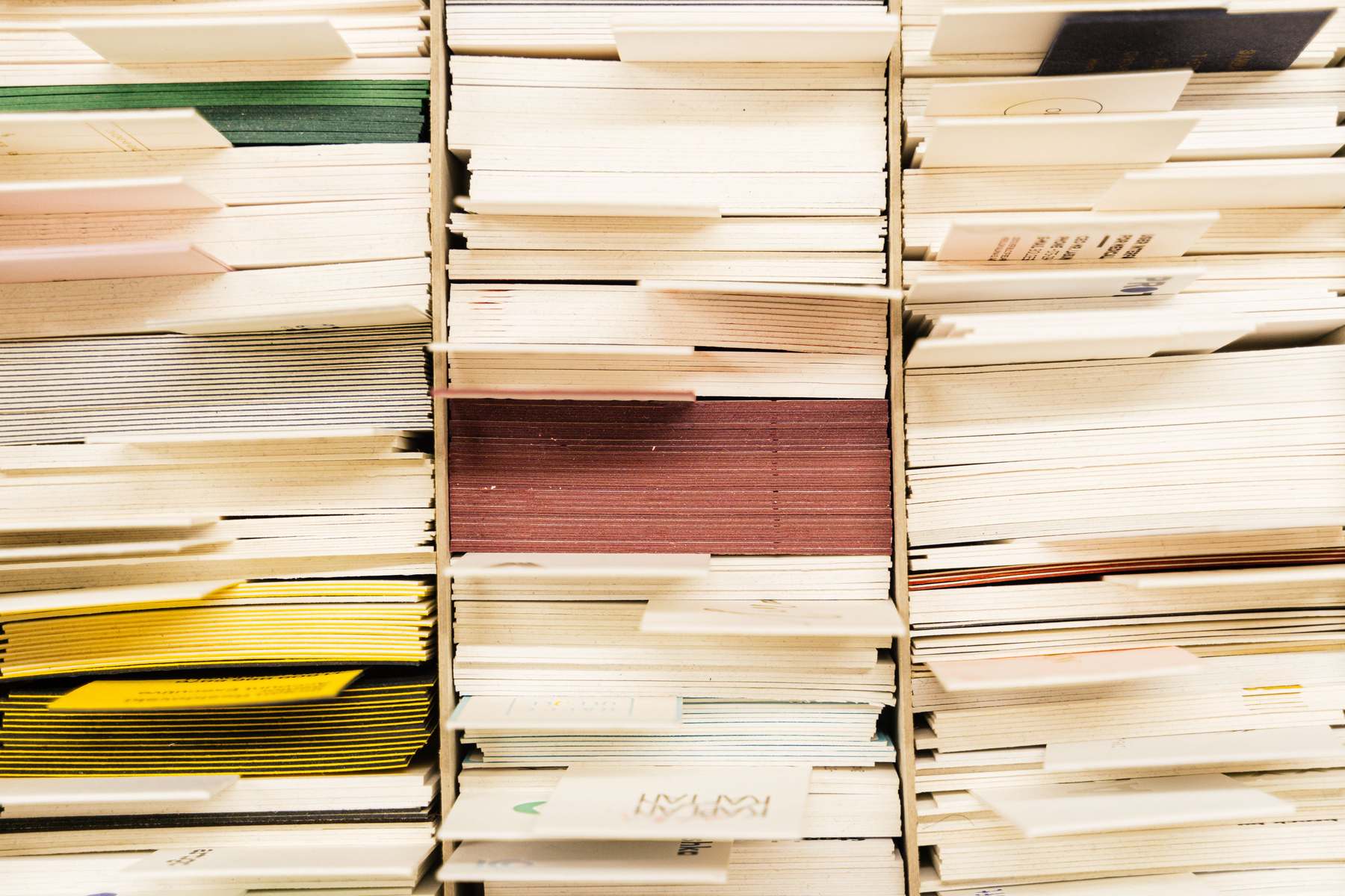 Close-up view of stacked colorful documents and cards, divided into neat rows