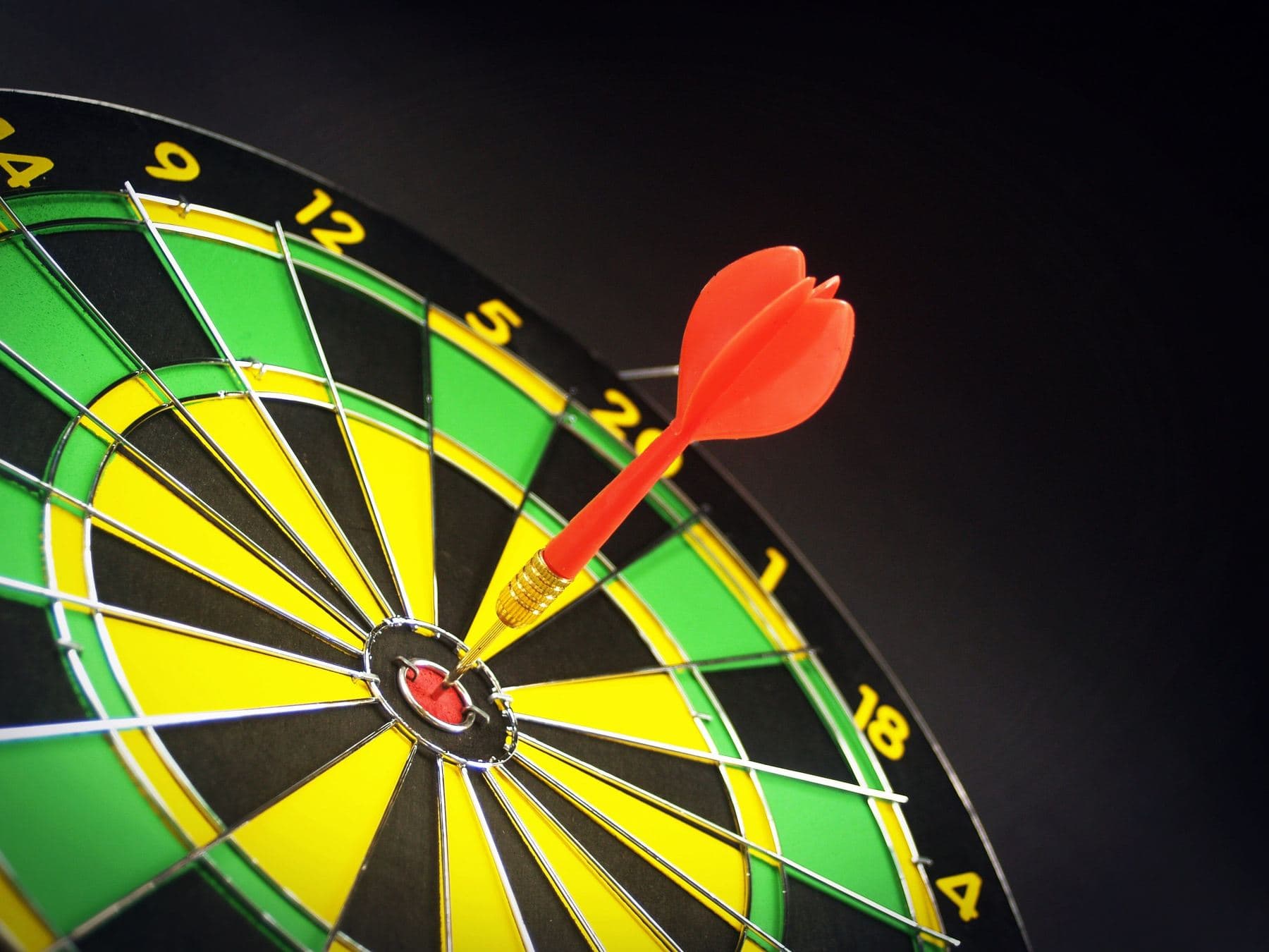 A red dart planted right at the centre of a dartboard